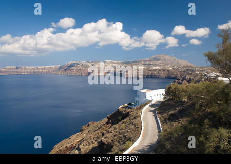 Akrotiri, Santorin, südliche Ägäis, Griechenland. Blick entlang der kurvenreichen Küstenstraße hoch über das tiefblaue Wasser der Caldera. Stockfoto