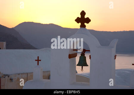 IA, Santorini, südliche Ägäis, Griechenland. Glockenturm der typisch weiß getünchten Kirche, Sonnenaufgang. Stockfoto