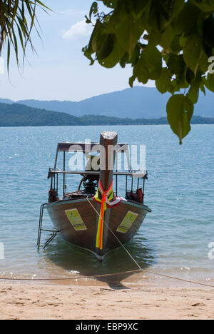 Ein Longtail-Boot ist auf einem exotischen Thai Strand geparkt. Stockfoto