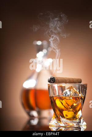 Zigarre auf Glas mit Whiskey auf braunem Hintergrund Stockfoto