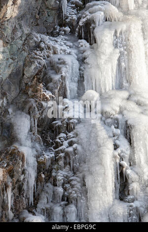 Eisfall auf einem steilen Felsen mit zauberhaften Mustern im Morgenlicht. Stockfoto