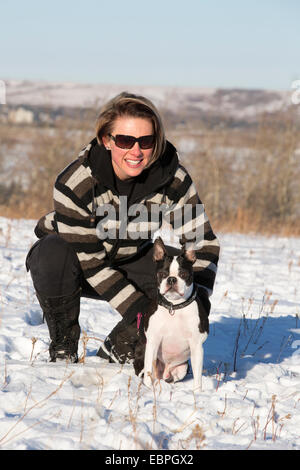 Frau mit dem 11 Jahre alten Boston Terrier, die die Natur im Stadtpark genießt Stockfoto