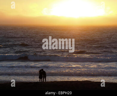 Mann und Frau küssten sich beim Sonnenuntergang am Meer Stockfoto