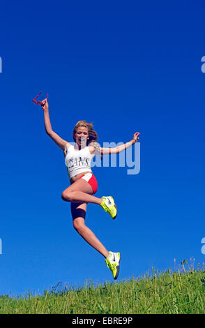 junge Frau auf einer Wiese springen Frankreich Stockfoto