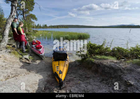 paar stand neben Kajaks am Seeufer und auf Rogen See, Schweden, Haerjedalen, Naturreservat Rogen Stockfoto