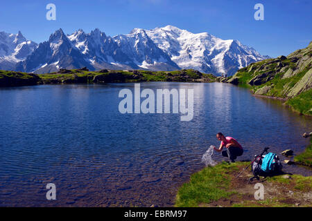 Berg-Wanderer Erfrischung am Lac de Chesery, Mont Blanc im Hintergrund, Chamonix, Haute-Savoie, Frankreich Stockfoto