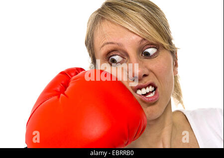junge Frau empfängt einen Schlag in das Gesicht mit einem Boxhandschuh Stockfoto