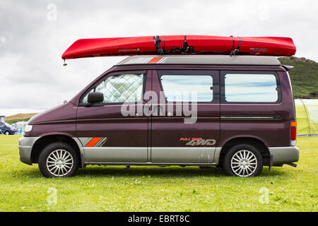 Mazda Bongo Wohnmobil mit einem roten zwei-Mann-Kajak an den Dachgepäckträger geschnallt. Stockfoto