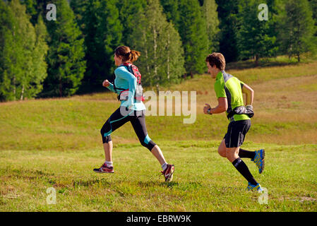 junges Paar laufen auf einer Wiese, Frankreich, Savoie Stockfoto