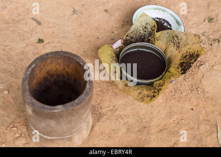 Indonesische schwarz Kaffeebohnen gemahlen in Terrakotta Mörser von Hand. Selektiven Fokus. Stockfoto