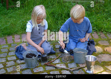 zwei Kinder mischen Böden, Malen mit Erde Farbe, Deutschland Stockfoto