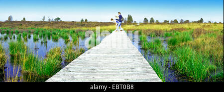 zwei Personen auf Holzweg durch Sumpf, Steinley Fen, Belgien, hohe Venn, Muetzenich Stockfoto