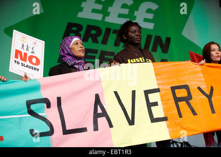 Anti-Sklaverei-Aktivisten auf der Bühne bei einem Protest gegen sinkende Löhne in London am 18. Oktober 2014 sammeln. Stockfoto