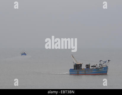 Hastings, East Sussex, Großbritannien. Dezember 2014. Ein kalter, nebelbesetzter Nachmittag mit Temperaturen, die sich dem Gefrierpunkt nähern, als Fischerboote an der Südküste auf See fahren Stockfoto