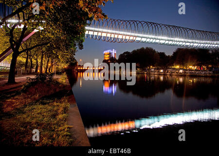 beleuchtete Slinky Springs zu Ruhm zu überbrücken, Rehberger Bruecke im Rhein-Herne-Kanal, Gasometer Oberhausen im Hintergrund, Oberhausen, Ruhrgebiet, Nordrhein-Westfalen, Deutschland Stockfoto