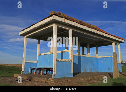 East Kent Küste - Minnis Bucht, England - verwitterte Holz Sitzecke mit Ziegeldach an einem sonnigen Herbsttag Stockfoto