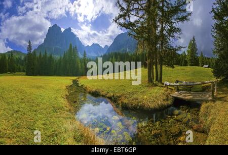 Brook Pares Wicklung Throught die Almwiesen in Campill-Tal, im Hintergrund der Geisler-Gruppe, Italien, Südtirol, Dolomiten, Naturpark Pütz-Geisler Stockfoto