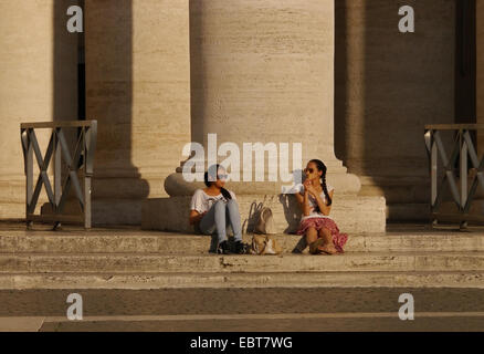 Zwei Frauen entspannen am Fuße der Säulen in Markusplatz entfernt, Rom, Italien Stockfoto