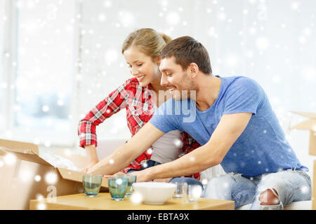 lächelnde paar Eröffnung Karton mit Geschirr Stockfoto