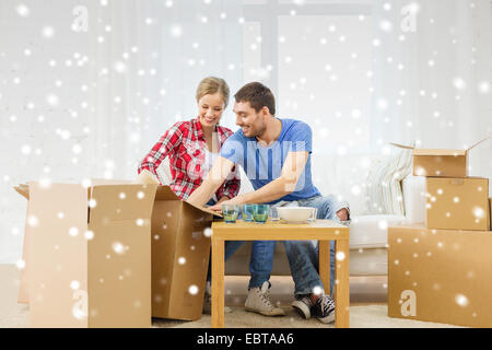 lächelnde paar Eröffnung Karton mit Geschirr Stockfoto