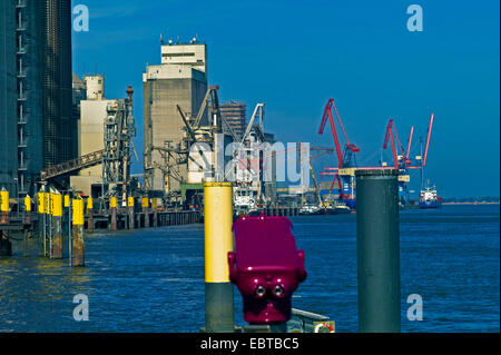 Getreidesilos am Ufer der Weser, Münze Teleskop im Vordergrund, Deutschland, Niedersachsen, Brake Stockfoto