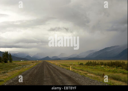 Landstraße durch eine weite Wiesenlandschaft, umgeben von Bergketten zwischen Mulakot und Barkarstadir, Island Stockfoto