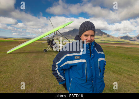 Junge Frau vor einem Ultraleicht Flugzeug, Island Stockfoto