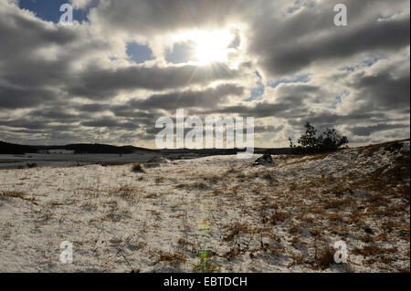 Sonnenstrahlen brechen durch Wolken über Wiese im Winter, Deutschland, Bayern, Oberpfalz Stockfoto