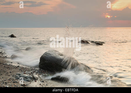 Findlinge in der Brandung der Ostsee bei Sonnenuntergang, Deutschland, Mecklenburg-Vorpommern Stockfoto