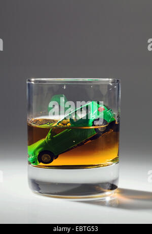 Spielzeugauto Untergang in einem Glas Alkohol Stockfoto
