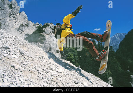 Mensch, während "Rockboarden" in den Bergen (hinunter eine Schotter-Piste auf einem Snowboard) Stockfoto