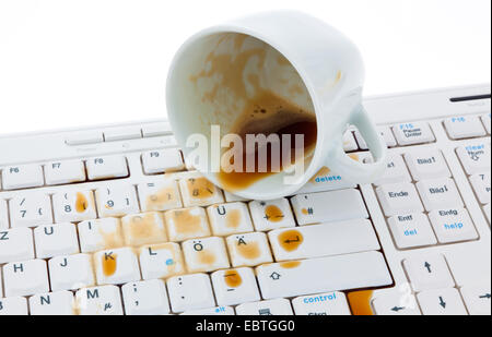 Tasse Kaffee verschüttet auf einer Computertastatur Stockfoto