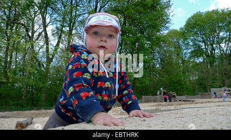 kleiner Junge spielt im Sandkasten auf Spielplatz Stockfoto