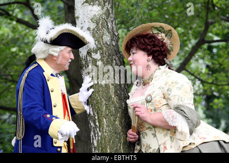 älteres Ehepaar trägt barocke Kleidung stehen an einem Garten Baum flirten Stockfoto