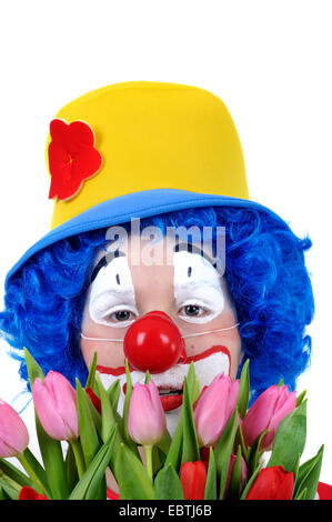 kleiner Junge verkleidete sich als Clown mit einem Blumenstrauß Stockfoto