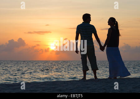 paar am tropischen Strand den Sonnenuntergang genießen Stockfoto