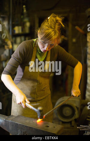 Frau Schmied arbeitet in einer Schmiede, viel Hadham, Hertfordshire, England, UK Stockfoto