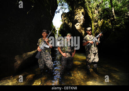 drei jungen Soldaten gehen durch Wasser, Honduras, Copan Stockfoto