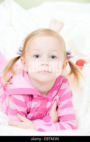 kleines Mädchen auf dem Bett auf dem Bauch liegend Stockfoto