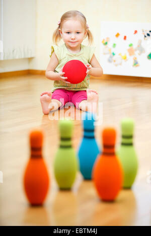 kleines Mädchen in der Baumschule bowling Stockfoto