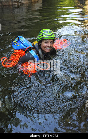 ältere Frau mit Kletterausrüstung im Wasser der Schlucht Vivaggio, Frankreich, Korsika Stockfoto