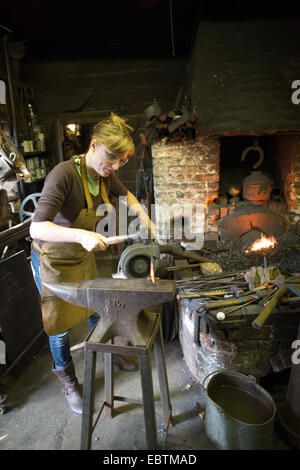 Frau Schmied arbeitet in einer Schmiede, viel Hadham, Hertfordshire, England, UK Stockfoto