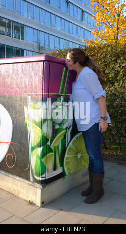 Lime Obst (Citrus Aurantifolia), Frau trinkt eine Caipirinha gemalt auf einem Panelboard, Deutschland, Nordrhein-Westfalen, Düsseldorf Stockfoto