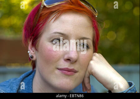junge rothaarige Frau mit Sonnenbrille auf der ernsthaften Suche Stockfoto