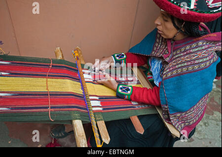 junge Frau in Tracht, die Arbeiten an einem Webstuhl bei der lokalen Werkstatt, Peru, Chincheros Stockfoto