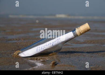 eine Flaschenpost am Sandstrand Stockfoto