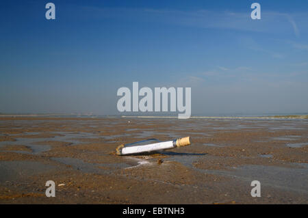 eine Flaschenpost am Sandstrand Stockfoto