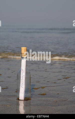 eine Flaschenpost am Sandstrand Stockfoto
