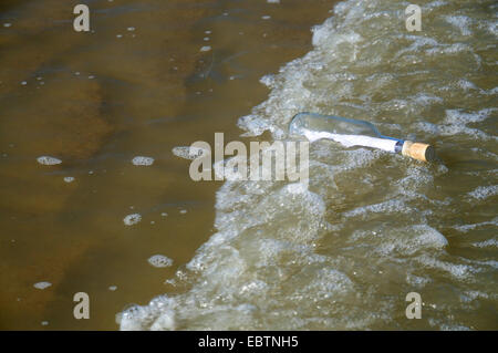 Nachricht in eine Flaschenreinigung bis zum Sandstrand Stockfoto