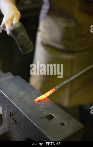 Frau Schmied arbeitet in einer Schmiede, viel Hadham, Hertfordshire, England, UK Stockfoto